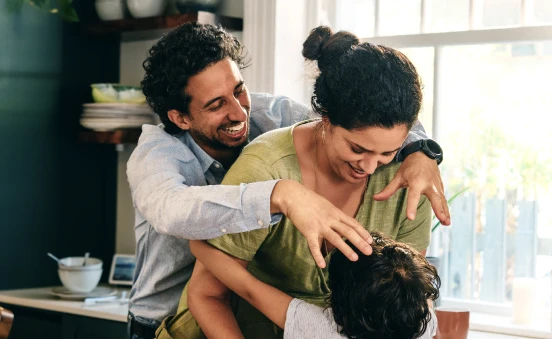 Familia feliz conviviendo en casa, ejemplo de protección familiar y bienestar asegurado con seguro de vida.